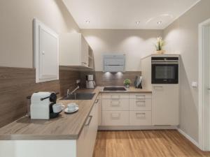a kitchen with white cabinets and a counter top at Strandburg "Tiefblau" 01 b in Burgtiefe auf Fehmarn 