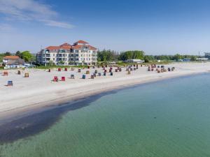 a view of a beach with chairs and a building at Strandburg "Tiefblau" 01 b in Burgtiefe auf Fehmarn 