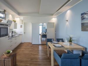 a kitchen and dining room with a table and blue chairs at Strandburg "Azurblau" 01 c in Burgtiefe auf Fehmarn 