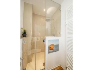a shower with a glass door in a bathroom at Strandburg "Azurblau" 01 c in Burgtiefe auf Fehmarn 