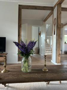 a vase of purple flowers on a table in a living room at Cozy big villa in Hanko in Hanko