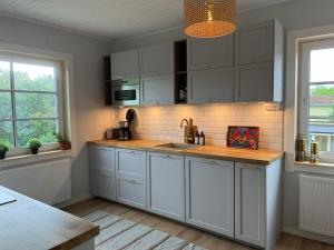 a kitchen with white cabinets and a wooden counter top at Cozy big villa in Hanko in Hanko