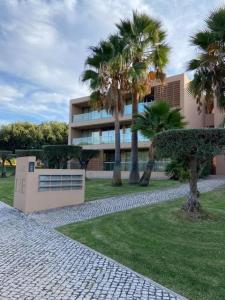 a building with palm trees in front of a building at Salgados Retreat in Bicas