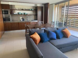 a living room with a blue couch and a kitchen at Salgados Retreat in Bicas