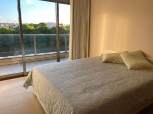 a bedroom with a bed and a large window at Salgados Retreat in Bicas