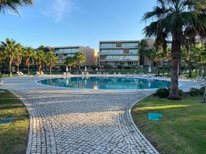 a swimming pool in a park with palm trees at Salgados Retreat in Bicas +22 photos