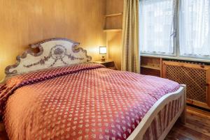 コルティーナ・ダンペッツォにあるVilla Cristallino -Stayincortinaのベッドルーム1室(オレンジと白の掛け布団付きのベッド1台付)