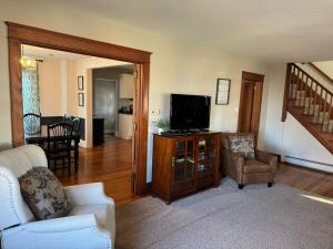 a living room with a tv and a couch and chairs at Comfortable Craftsman Getaway in Lancaster