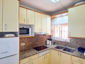 a kitchen with a sink and a microwave at Seafront L'Estartit Roof in L'Estartit