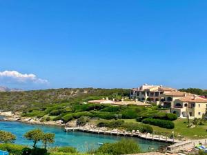 a large house on a hill next to a river at Suite Rea Beachfront - Giardino & Spiaggia Privata - by Coral Property in Porto Cervo