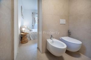 a bathroom with a white toilet and a sink at Suite Rea Beachfront - Giardino & Spiaggia Privata - by Coral Property in Porto Cervo +29 photos