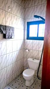 a bathroom with a white toilet and a window at Velo Apartments in Kribi in Kribi +11 photos