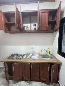 a kitchen with a sink and a stove at Velo Apartments in Kribi in Kribi