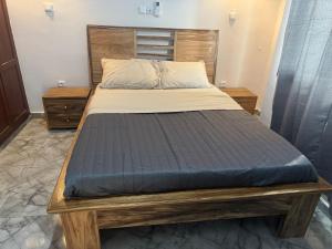 a bed in a bedroom with a wooden bed frame at Velo Apartments in Kribi in Kribi