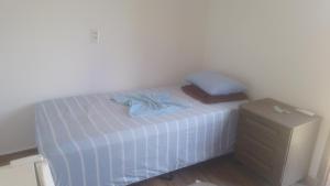 a small bed with a blue shirt on top of it at Pousada santa Clara in Matão