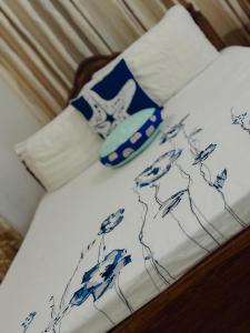a bed with a blue and white comforter on it at Nathalie Villa in Anuradhapura
