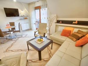 un soggiorno con divano e tavolo di VisitZakopane - Flower Apartment a Zakopane