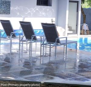 a group of chairs sitting next to a pool at The Blue Eco Lodge in Valladolid