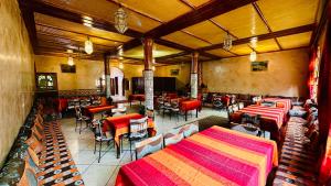 a restaurant with tables and chairs in a room at Chez Ali Zagora Authentic Hotel Restaurant and Desert Excursions in Zagora