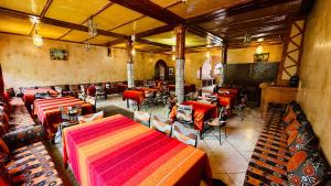 a restaurant with tables and chairs in a room at Chez Ali Zagora Authentic Hotel Restaurant and Desert Excursions in Zagora