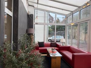 a living room with a red couch and a table at Wagners Hotel im Thüringer Wald in Tabarz