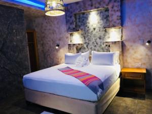 a bedroom with a large white bed and a lamp at Makgadikgadi Riverview Inn in Nata