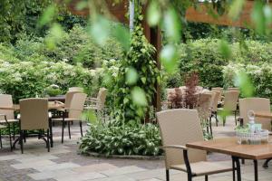 a group of tables and chairs in a garden at Hotel Backenköhler in Ganderkesee