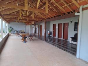a large covered patio with a table and chairs at Pousada santa Clara in Matão