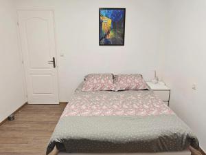 a bedroom with a bed and a painting on the wall at Jolie chambre au centre Antony in Antony