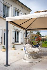 a chair under an umbrella on a patio at La Pierre Précieuse in Château-Thierry