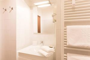 a white bathroom with a sink and a mirror at Loppia Bay View Apartment in Bellagio +29 photos