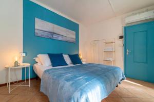 a blue bedroom with a bed and a blue wall at Azure Comfort Studio in Bellagio