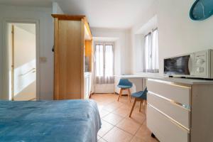 a bedroom with a bed and a desk with a microwave at Azure Comfort Studio in Bellagio