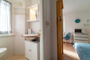 a small bathroom with a sink and a toilet at Azure Comfort Studio in Bellagio