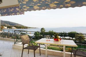 a table and chairs on a balcony with a view of the ocean at Galazia Akti in Agios Nikolaos