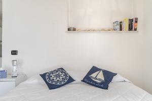a bedroom with a bed with two pillows on it at Una Terrazza sul Mare The Lighthouse in Paola