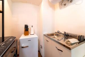 a small kitchen with a sink and a refrigerator at Lilliput Tiny Studio in Bellagio