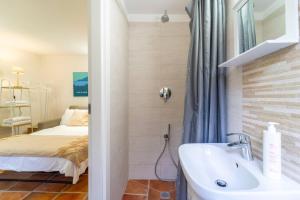a bathroom with a sink and a bed at Lilliput Tiny Studio in Bellagio