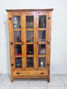 a wooden cabinet with glass doors at Casa luz e conforto Passos Capitólio in Passos