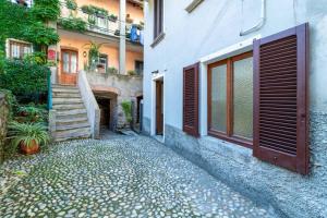 a building with a door and a stairway next to a house at Lilliput Tiny Studio in Bellagio +10 photos