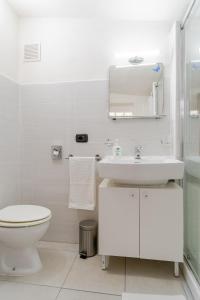 a white bathroom with a toilet and a sink at Una Terrazza sul Mare The Lighthouse in Paola +50 photos