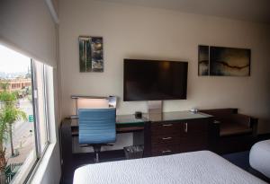 una camera da letto con una scrivania con una televisione e una sedia di Hotel Nelson a Tijuana