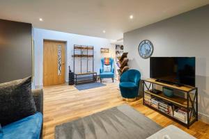 a living room with a couch and a flat screen tv at Spacious 2BR with garden in Alnwick