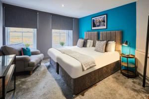 a bedroom with a large bed and a couch at Spacious 2BR with garden in Alnwick