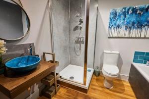 a bathroom with a shower and a blue sink at Spacious 2BR with garden in Alnwick +29 photos