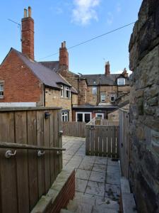 a yard with a fence and houses in the background at Spacious 2BR with garden in Alnwick
