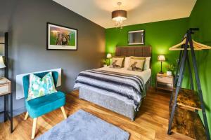 a bedroom with a bed and a green wall at 1BR Private Lodge inc Sofa Bed in Alnwick