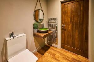 a bathroom with a toilet and a sink and a mirror at 1BR Private Lodge inc Sofa Bed in Alnwick +10 photos