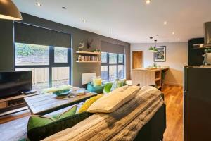 a living room with a large couch and a tv at 1BR Private Lodge inc Sofa Bed in Alnwick