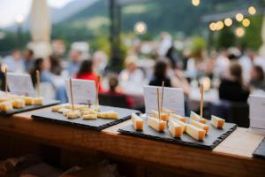 a table topped with plates of cheese on sticks at Hotel Der Waldhof in Vollan
